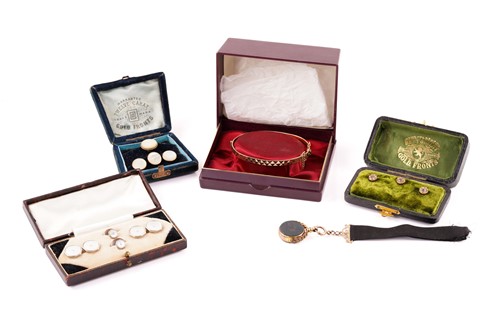 Lot 107 - A 9ct gold bangle, a 9ct gold swivel fob and...