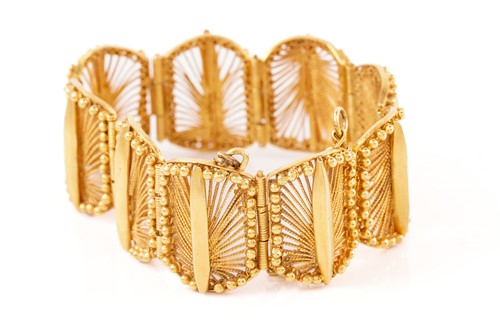 Lot 225 - A yellow gold bracelet formed of nine curved...