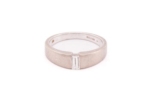 Lot 143 - A baguette-cut diamond solitaire ring in 18ct...