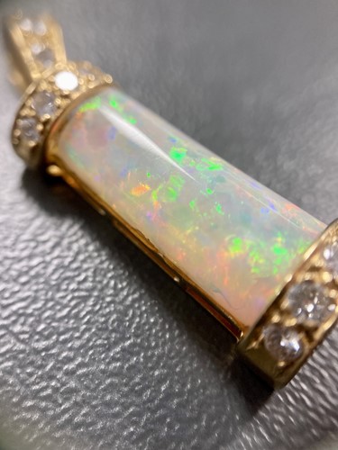 Lot 69 - An opal and diamond pendant, the tapering...
