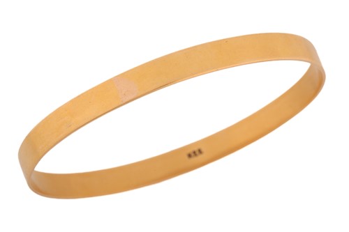 Lot 117 - A yellow metal closed bangle, with a solid...