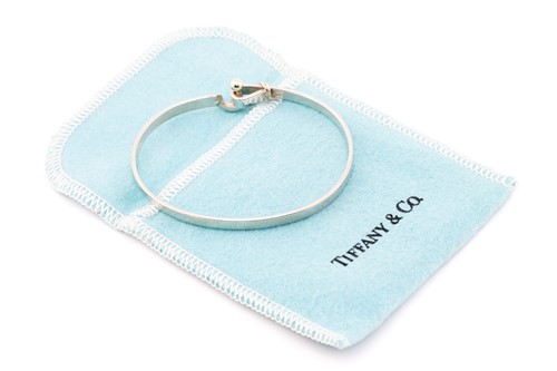 Lot 130 - Tiffany & Co. - A two-tone hook and eye bangle,...