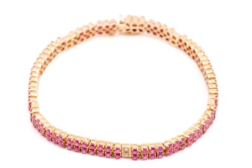 Lot 162 - A yellow metal, ruby and diamond line bracelet;...
