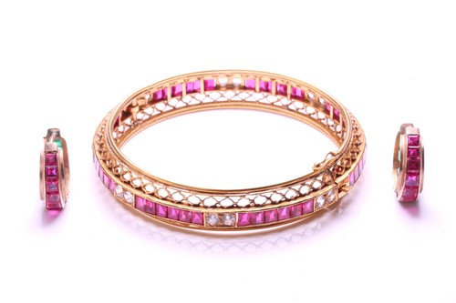 Lot 87 - A hinged bangle set with synthetic ruby and...
