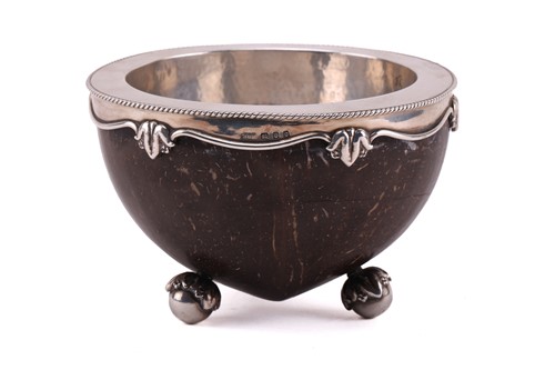 Lot 465 - A late Arts & Crafts silver mounted coconut...