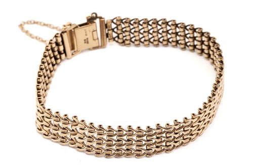Lot 245 - A 9ct yellow gold flat mesh link bracelet with...