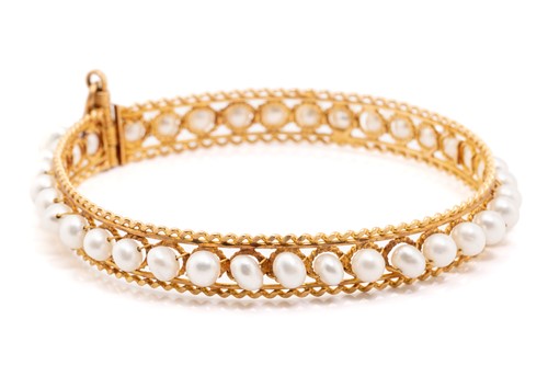 Lot 265 - A pearl-set bangle, comprising a row of potato-...