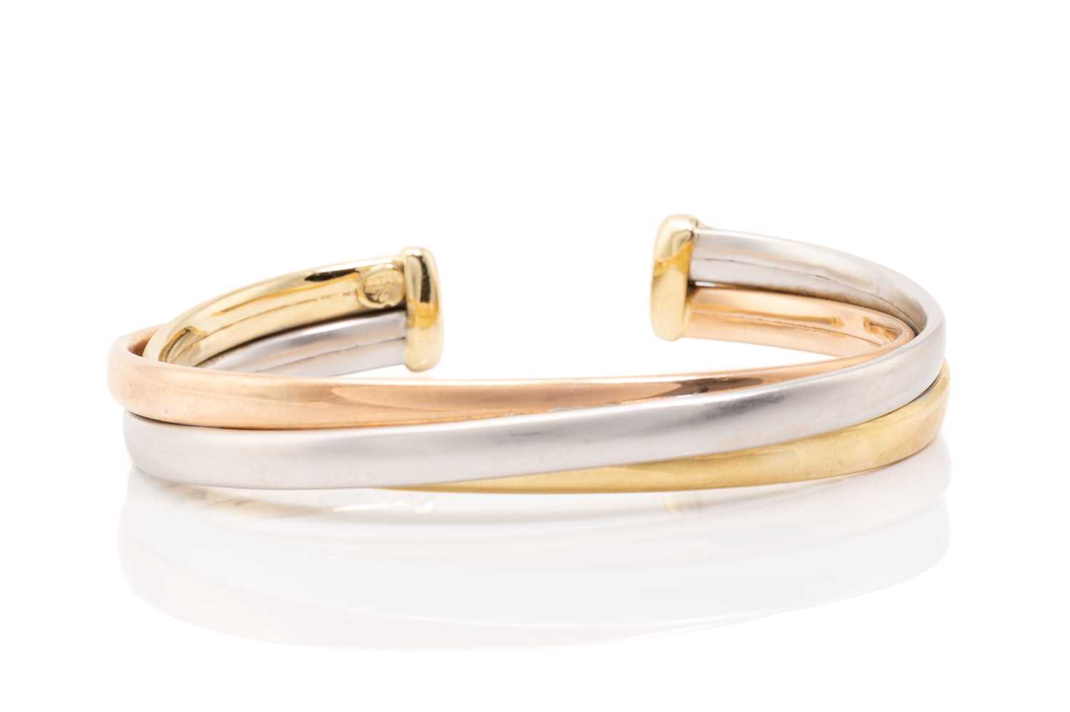 Lot 91 - A tri-coloured torque bracelet consisting of...