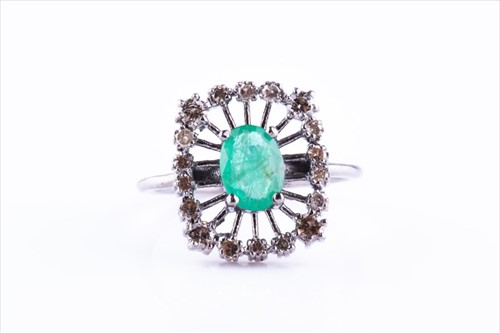 Lot 492 - A diamond and emerald ring of openwork...