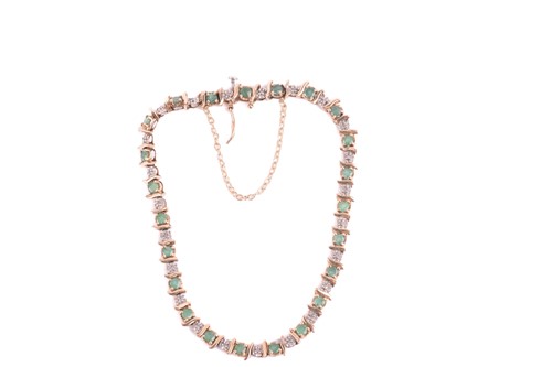 Lot 50 - An emerald and diamond line bracelet in 9ct...