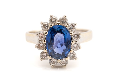 Lot 68 - A sapphire and diamond cluster ring; the oval...