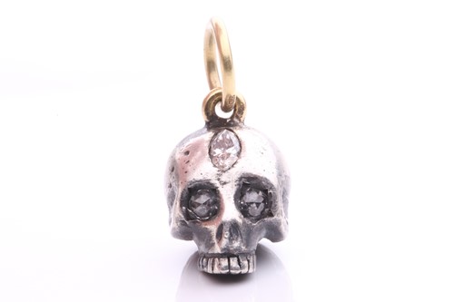Lot 44 - A diamond-set skull charm pendant in silver...
