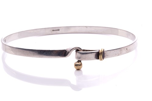 Lot 219 - Tiffany & Co. - A two-tone hook and eye bangle,...