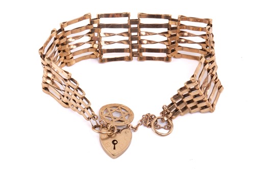 Lot 68 - A six-row gate link bracelet with charm in 9ct...