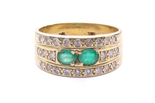 Lot 102 - An emerald and diamond ring set with two...