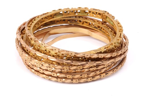 Lot 275 - A collection of yellow metal bangles;...