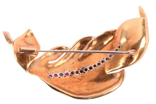Lot 178 - A ruby and sapphire feather brooch in textured...