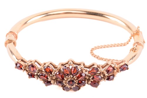 Lot 298 - A garnet bangle, set with a floral cluster of...