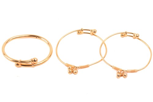 Lot 208 - Three child's expanding bangles in high carat,...