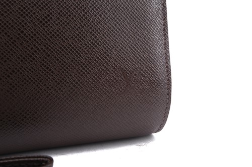 Lot 22 - Louis Vuitton - a clutch bag in dark brown...
