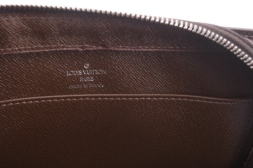 Lot 22 - Louis Vuitton - a clutch bag in dark brown...