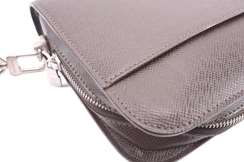 Lot 22 - Louis Vuitton - a clutch bag in dark brown...