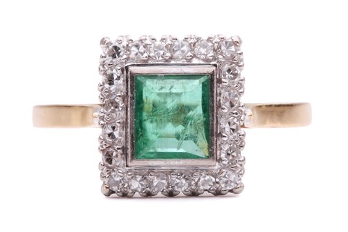 Lot 11 - An emerald and diamond halo ring, featuring a...