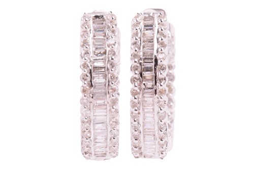 Lot 18 - A pair of diamond-set huggy hoop earrings in...