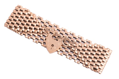 Lot 111 - A tapering gate bracelet with a heart-shaped...