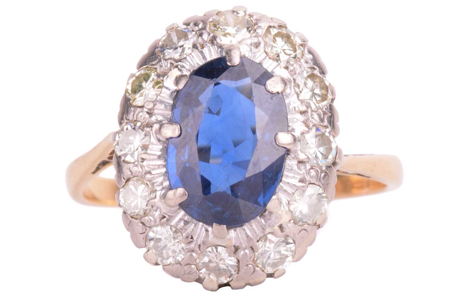 Lot 75 - A sapphire and diamond cluster ring. Oval-cut...