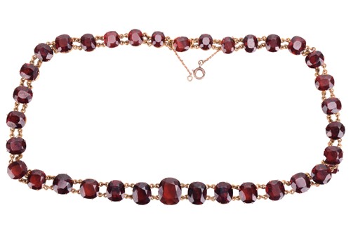 Lot 80 - A red garnet rivière necklace in gilt metal,...