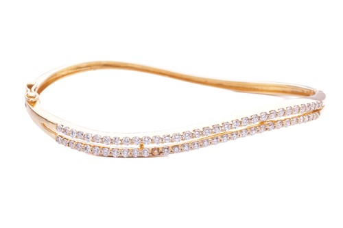 Lot 10 - A diamond-set hinged oval bangle, constructed...