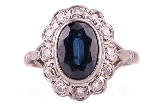 Lot 15 - A sapphire and diamond entourage ring, centred...