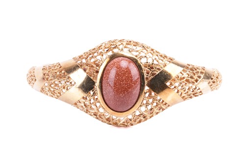 Lot 26 - An oval hinged bangle, bezel set with a...