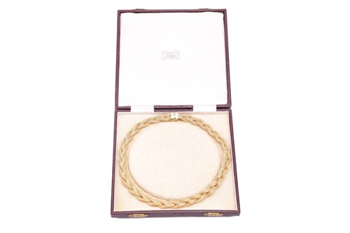 Lot 13 - A braided mesh necklace in 18ct yellow gold,...