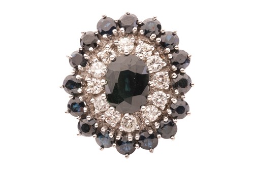 Lot 37 - A sapphire and diamond cluster ring, featuring...