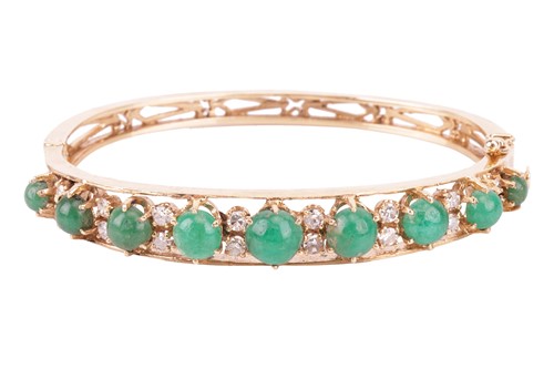 Lot 18 - An emerald and diamond bangle, featuring a row...