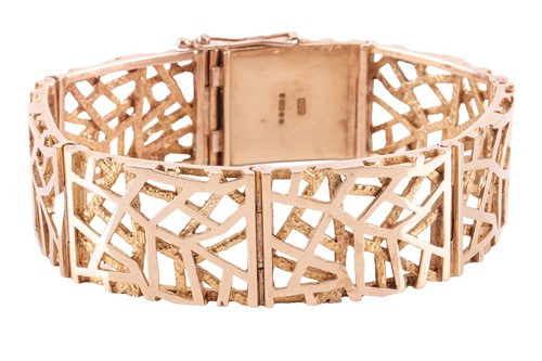 Lot 45 - A 9ct gold panel bracelet. The textured gold...