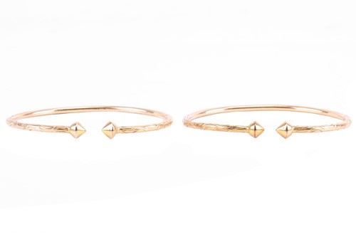 Lot 28 - A pair of torque bangles, part engraved with...