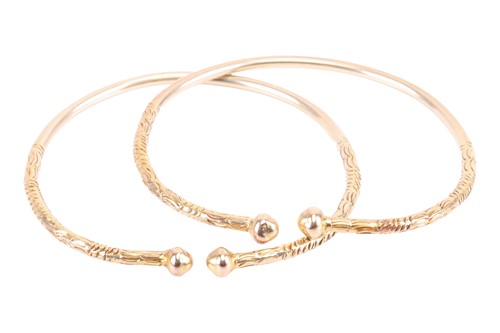 Lot 67 - A pair of torque bangles; part engraved with...
