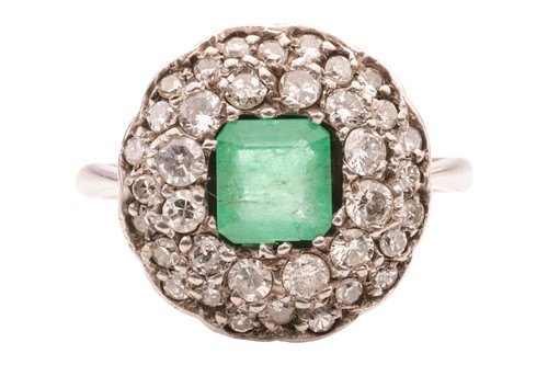 Lot 143 - An emerald and diamond cluster ring, centred...