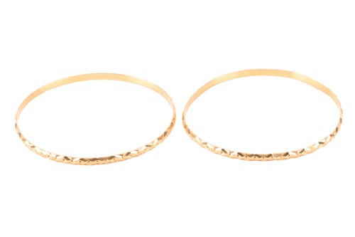Lot 114 - A pair of bangles, the closed bracelets with...