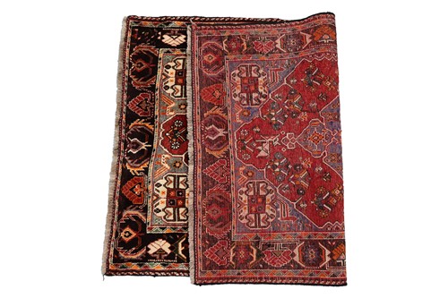 Lot 144 - A plum-coloured ground Baktiari rug with a...