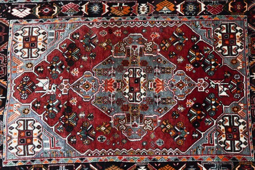 Lot 144 - A plum-coloured ground Baktiari rug with a...