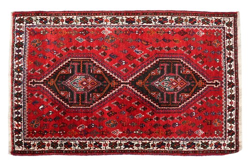 Lot 145 - A red ground Qashqai rug with two diamond...