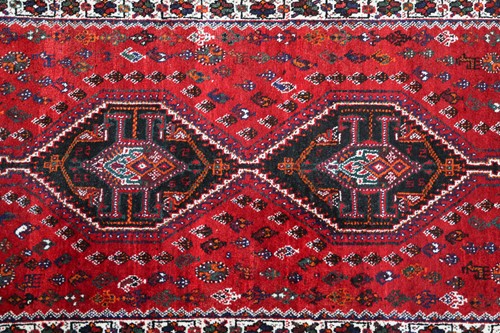 Lot 145 - A red ground Qashqai rug with two diamond...