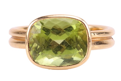 Lot 99 - A peridot dress ring in 18ct gold, collet-set...