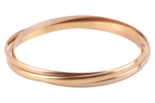 Lot 179 - Cartier – a trinity bangle in 18ct gold,...