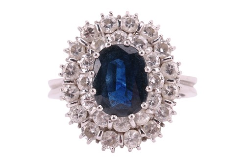 Lot 138 - A sapphire and diamond cluster ring, centred...