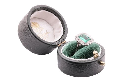 Lot 233 - An emerald and diamond-set cluster ring, the...